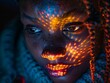 © Nattanon - close-up of a woman's face. The woman has dark skin and her face is illuminated by a pattern of bright orange lights.