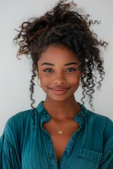 Wall Mural - A woman with curly hair and a gold necklace is smiling