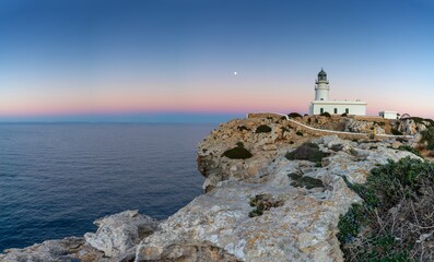 Canvas Print - view of the Cap de Cavalleria Lighthouse on Menorca at sunset with a full moon rising