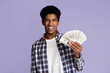 © Prostock-studio - Finance and money saving. Excited guy holding lots of dollars, pink studio background