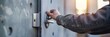 © gunzexx png and bg - Close-up of a person's hand inserting a key into a metallic door lock, symbolizing security and access control