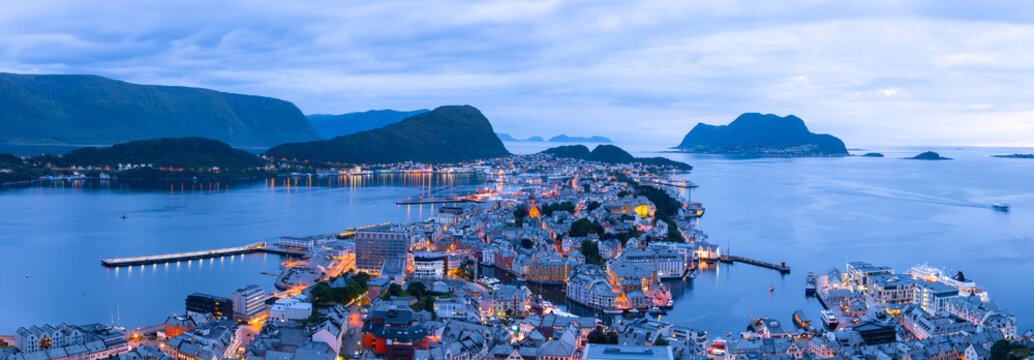 panorama of norwegian port town alesund in evening time. norway cityscape with fjord, islands, mount
