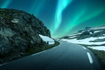 Wall Mural - aurora borealis northern lights in night winter sky above the famous mountain snowy road in norway