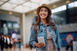© Drazen - Young happy woman using mobile phone at departure terminal.