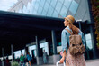 © Drazen - Rear view of happy female traveler at airport.