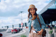 © Drazen - Happy female tourist at airport looking at camera.