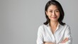 © Leli - A confident woman in a white shirt stands with her arms crossed