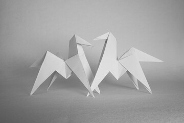 Paper origami of white horses on a white background
