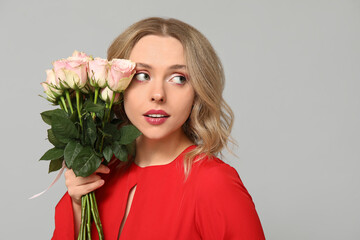 Sticker - Young woman with bouquet of beautiful roses on grey background