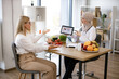 © sofiko14 - Arab female doctor makes treatment plan for gastrointestinal tract in modern clinic. Professional nutritionist tells patient about benefits of healthy diet while holding tablet with graphs in hands.