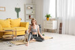 © Pixel-Shot - Sporty young woman with cute Beagle dog sitting on yoga mat at home