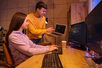 Wall Mural - Couple of programmers working in office at night