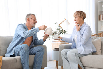 Wall Mural - Mature deaf mute couple pouring tea at home