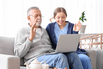 Poster - Female caregiver with senior man video chatting in nursing home