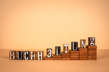 Wall Mural - Accounting word in German. Wooden alphabet letters on a light background