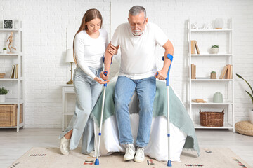 Poster - Nurse helping senior man with crutches in bedroom