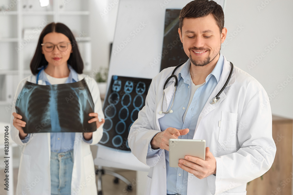 Male doctor working with tablet computer in clinic
