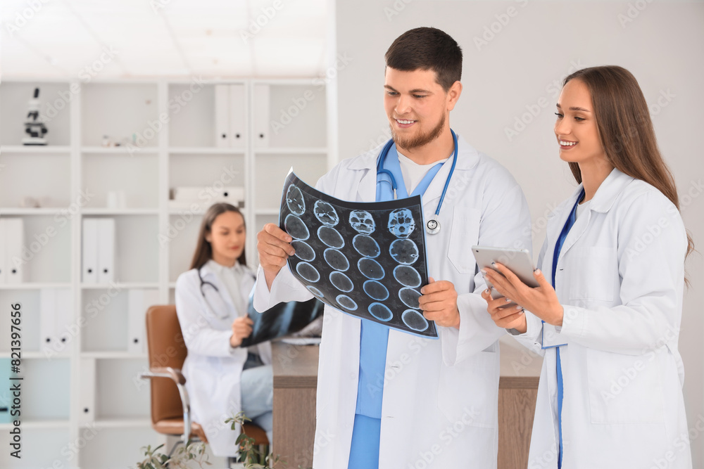 Smiling doctors studying MRI scan at hospital