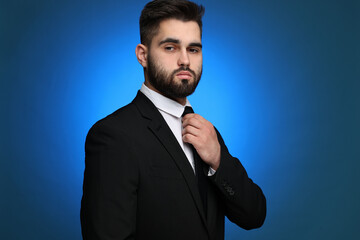 Wall Mural - Handsome businessman in suit and necktie on blue background