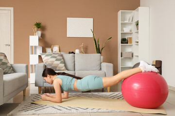 Sticker - Sporty young woman training with fitball on mat at home