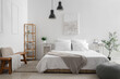 © Pixel-Shot - Interior of stylish bedroom with cozy bed, shelving unit, bedside table and olive tree