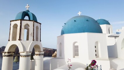 Canvas Print - Establishing shot of Oia, white church belfry, blue domes and volcano caldera with sea landscape, establishing shot of Santorini island, Greece