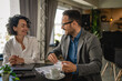 © Miljan Živković - Man and woman on break at cafe drink coffee check list on clipboard