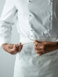 © The Picture Pantry - Chef tying apron in chefs whites