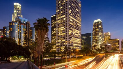 Fototapete - Hyperlapse walk into downtown Los Angeles over freeway traffic as city skyline changes from sunset to night. 4K timelapse.