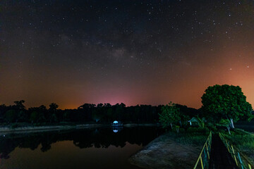 star natural background At night, the Milky Way can be clearly seen with the naked eye, with the blur of light hitting the water surface and the cool, humid air.