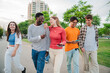 © Jose Calsina - Youthful Conversations on a meeting: Big group of joyful friends walking and chatting together on daytime. Multiracial young buddies talking, having fun on a social gathering. Teenagers hanguing out