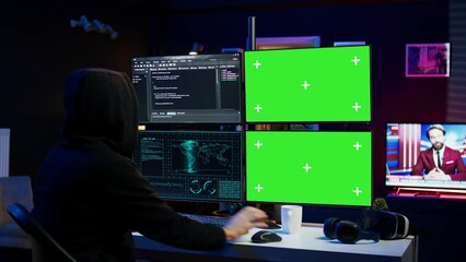 Wall Mural - Hooded man writing lines of code on green screen PC from apartment, trying to get past security systems. Evil hacker using mockup computer to make scripts that can hack devices, camera B