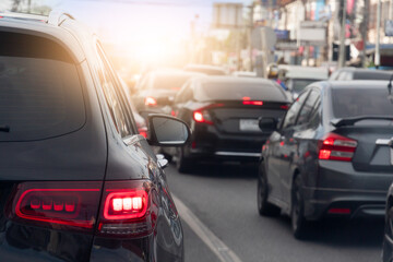 Wall Mural - Rear side of cars on asphalt roads. With turn on brake light. During time in rush hours for travel or business work in the city. with effect orange light for background.