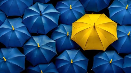 Yellow umbrella standing out among blue umbrellas