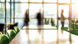 ©  Made with Matcha - Empty office room tables and green chairs in modern corporate meeting space with blurry silhouettes of people meeting in background