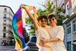 © Westend61 - Happy young couple waving rainbow flag at gay pride parade