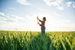© standret - Far view, standing. Young woman is on the beautiful agricultural field at daytime