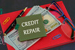 © Ihar - Business, finance and fix your credit here concept. Concept words CREDIT REPAIR on a sticker on the background of a business notebook and dollars