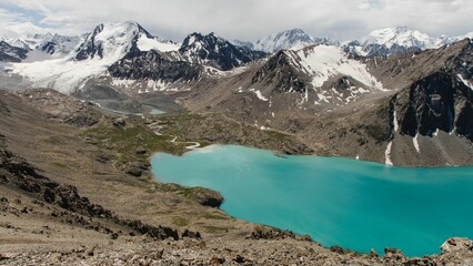 Wall Mural - Turquoise Ala-Kol mountain lake surrounded by snowcapped mountains in Kyrgyzstan.