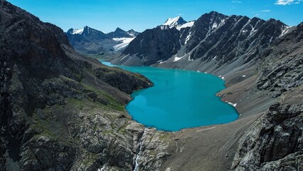 Poster - Turquoise Ala-Kol mountain lake surrounded by snowcapped mountains in Kyrgyzstan.