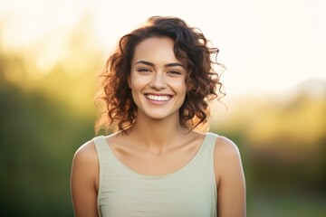 Wall Mural - Portrait of a grinning woman in her 20s smiling at the camera isolated in solid pastel color wall