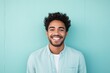 © Markus Schröder - Portrait of a smiling indian man in his 20s smiling at the camera isolated in solid pastel color wall