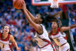 © BetterPhoto - Female basketball player jumping to make a pass during a game