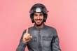 © Fotograf - A man wearing a motorcycle helmet giving a thumbs up sign. Suitable for promoting motorcycle safety