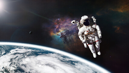 Wall Mural - cosmonaut in outer space against earth planet. elements of this image furnished by nasa.