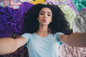 High angle view photo of young girl make selfie kiss lips pile stack clutter clothes apartment indoors