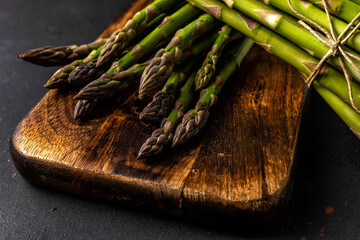 Wall Mural - View of fresh asparagus on a black table. Food background.