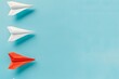© MD - Red Paper Airplane Leading Among White Ones on Blue Background