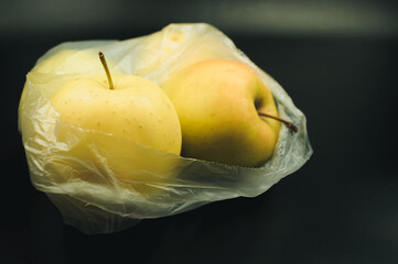 Wall Mural - A bag of apples is sitting on a black surface