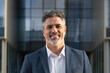 © Stock 4 You - Proud older senior businessman professional ceo, manager, leader looking camera near city office. Closeup face portrait of smiling confident 40s latin hispanic mature business man standing outdoors